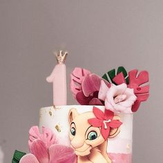 a birthday cake decorated with pink flowers and an image of the lion king on top