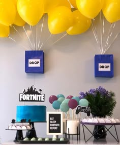 a table topped with lots of yellow and blue balloons next to a white counter top