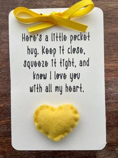 a yellow heart pinned to a piece of paper with a poem written on it that says, here's a little pocket hug keep it close, squeeze