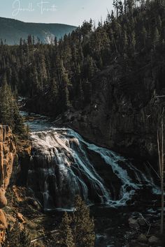 a large waterfall surrounded by trees and rocks