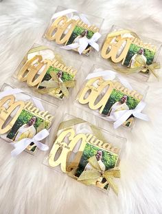 four clear acrylic coasters with gold letters and bows