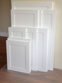 four white doors are stacked on top of each other in a room with hard wood flooring