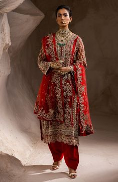 Pakistani Wedding Dress in Red Kameez Sharara Style is an iconic attire that will give you a magnificent look on the big day. The traditional and glamorous look of this Pakistani Dress makes it the epitome of beauty and your priority to have a flawless look. Red Kameez: The kameez in an alluring red shade has premium quality fabric. The lavish designs and hand-crafted details of shimmering sequins, tilla, and beads make this beautiful Red kameez a perfect choice to wear on the wedding. Its tradi Red Pakistani Dress, Sharara Style, Red Sharara, Pakistani Sharara, Punjabi Outfits, Pakistani Wedding Dress, Pakistani Dress, Pakistani Wedding Dresses, Net Dupatta