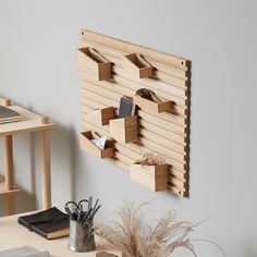 a wooden wall mounted shelf on the side of a white wall next to a desk