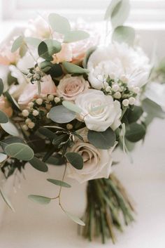 a bouquet of flowers and greenery on a table