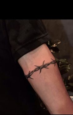 a tattoo with barbed wire on the arm