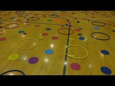 an indoor basketball court with colorful circles on it