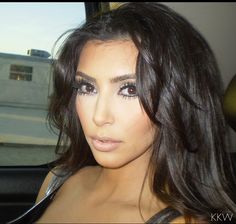 a close up of a person in a car with long dark hair and blue eyes