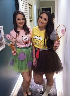 two women dressed in costumes standing next to each other holding tennis racquets