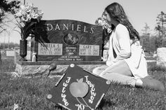 a woman sitting on the ground in front of a headstone with an apple sign