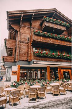 the outside of a building with tables and chairs in front of it on a snowy day