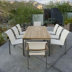 a wooden table with white chairs around it