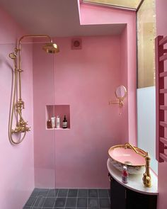 a bathroom with pink walls and gold fixtures