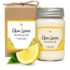 a jar of clean lemon scented soy candle next to a box with the lid open