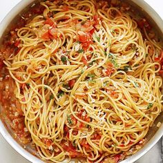 a pan filled with spaghetti and sauce on top of a table