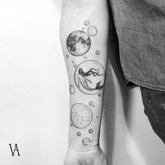 a person with a clock and planets tattoo on their arm is holding the hand of another person