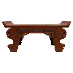 a wooden table with carvings on the top and bottom, sitting against a white background