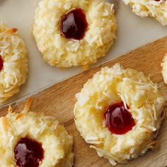 coconut cookies with jelly and coconut flakes on a cutting board