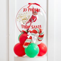 a glass ornament with an elf on it and balloons in front of it