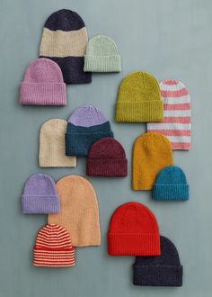 six knit beanies arranged in different colors on a gray background, one is multicolored