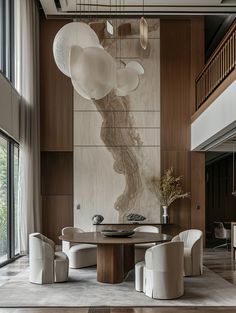 an elegant dining room with modern chairs and art work on the wall behind it, along with large windows