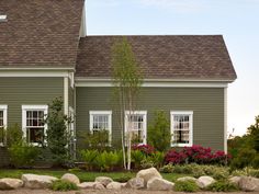 a house with green siding and white windows