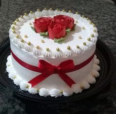 a heart shaped cake with two roses on top