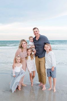 a family posing for a photo on the beach