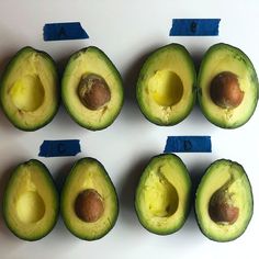 an avocado is cut in half on a white surface