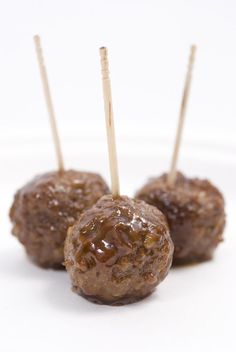 three chocolate covered donuts with toothpicks sticking out of them