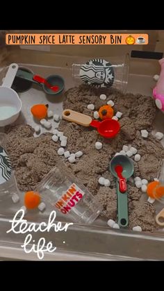 a tray filled with lots of sand and plastic spoons