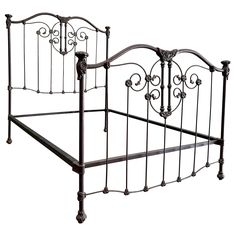 a metal bed frame with ornate designs on the headboard and foot board, against a white background