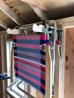 a towel rack in the corner of a room with wooden walls and ceiling boards attached to it