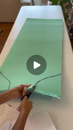 a person cutting paper with scissors on a table