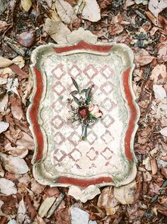 a small decorative object on the ground surrounded by leaves