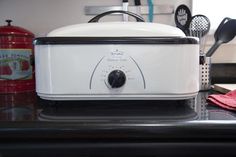 a toaster sitting on top of a counter next to utensils