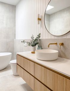 a bathroom with a sink, mirror and toilet in it's corner area next to a bathtub