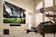 two people are playing soccer in the living room with their feet up on the television