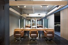 an empty room with chairs and desks in front of a mirror on the wall