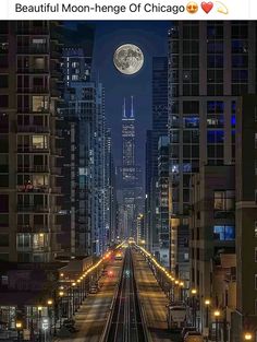 an image of a city at night with the moon in the sky and train tracks running through it