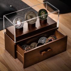 a wooden box filled with coins on top of a table