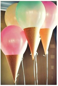 three ice cream cones with balloons attached to them