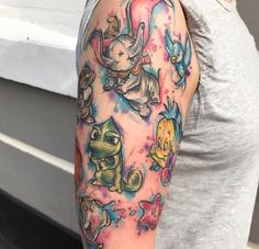 a woman's arm with tattoos on it, including an elephant and other cartoon characters