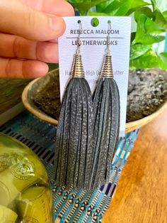 'Phyllis' Statement Tassel Earring-Black Your go to earrings for all occasions.  Whether your wearing your favorite tank top or going to a special occasion...these ladies will compliment all of your outfits! Tassel earrings combined with Natural Stone make for a perfect Boho Earring. Each pair is handmade by yours truly, so truly unique and one of a kind. You have the option of Tassel earrings with or with out Natural Stone. Natural Stone choice is Rainbow Jade (shown on left side) or Jade-Vibrant Blue. Choose at checkout! -Made from premium leather, yet lightweight. -Accented with Natural Jade Stone-Turquoise color. -Dangle and Drop Length- Approximately 5" -All metals are Nickel-Free, non Allergenic. I have very sensitive skin so I only use metals that will never irritate sensitive skin. Silver Tassel Earrings With Fringe As Gift, Black Fringe Dangle Earrings, Black Tassel Earrings With Ear Wire As A Gift, Black Fringe Drop Earrings, Black Latkans Earrings For Gift, Leather Tassel Earrings, Boho Earring, Tassel Earring, Long Tassel Earrings