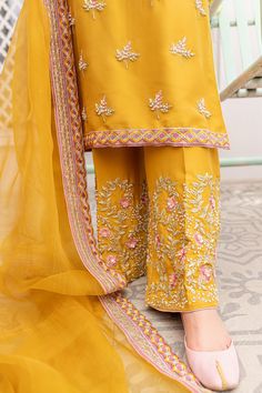 The elegant Pakistani Raw Silk Salwar Kameez Dupatta Dress is a traditional masterpiece to have a charismatic appearance on the big day. Embroidery, Resham, pearls, and sequins make this stunning Pakistani Salwar Kameez your foremost priority to have a breathtaking look. Kameez: The beautiful kameez in an alluring yellow mustard shade comes in premium raw silk fabric. The stunning kameez is emblazoned with graceful embroidery, Resham, and lavish designs. Hand-crafted embellishments of Swarovski Raw Silk Salwar, Mustard Yellow Outfit, Classy Couture, Punjabi Dress Design, Punjabi Suit Neck Designs, Dupatta Dress, Embroidery Suits Punjabi, Hand Embroidery Dress, Raw Silk Fabric