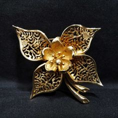 Vintage Coro Flower Brooch, Gold Plated, 1950s Jewelry *Description: This is a beautiful Coro flower brooch from the 1950s. It is 10 KG on the surface; acid tested. The flower has a brushed gold finish with open filigree petals and a solid brushed gold on the center. This would be a perfect wedding brooch. It would look beautiful on a wedding bouquet and be a keepsake for years to come. It would also make a great gift to wear on your favorite jacket, hat, or bag. *Approximate Measurements: Lengt Vintage Gold Flower Shaped Brooch, Vintage Flower Brooch For Evening, Vintage Flower Lapel Pin Gift, Vintage Flower Lapel Pin For Gift, Vintage Gold Flower Brooch, Vintage Gold Flower Brooches, Retro Flower Brooches For Collectors, Vintage Flower Brooches For Anniversary, Mid-century Flower Jewelry Gift