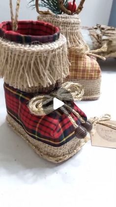 two baskets with rope wrapped around them sitting on a table next to a christmas tree