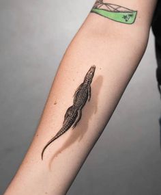 an arm with a lizard tattoo on it