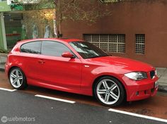 a red car parked in front of a building