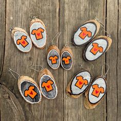 several pieces of wood that have been decorated with orange and white designs on them, sitting on a wooden surface